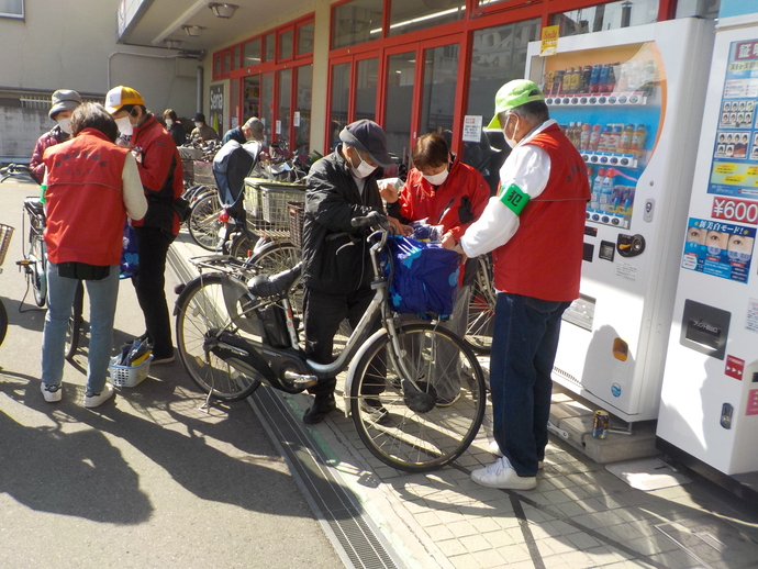 コノミヤ中もず店の前で赤いウィンドブレーカーやベストを着た方々がキャンペーンを行っている写真