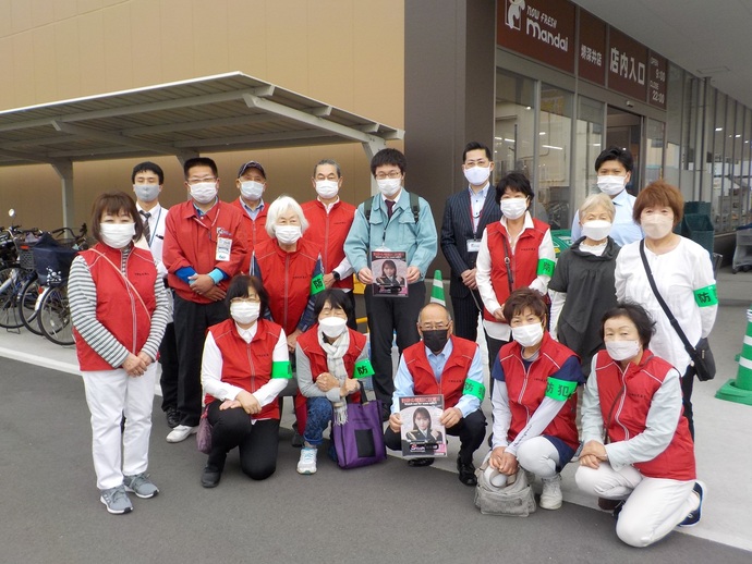 万代堺深井店の前で赤いベストを着た方々と関係者の方々が前列はしゃがみ、後列は立っている集合写真
