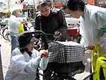 街頭で自転車のかごに、手作りのひったくり防止カバーを付けている写真