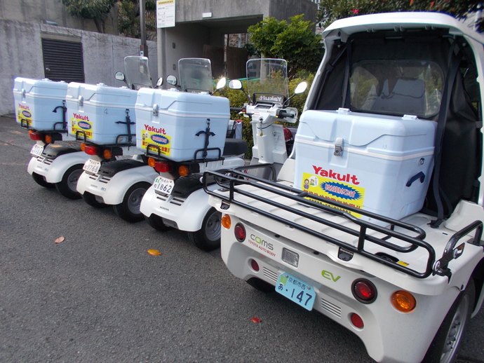 特殊詐欺被害防止啓発ステッカーが貼られたヤクルトの配達用の単車が4台並んでいる写真