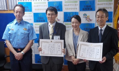 左から警察官、感謝状を持った男性、女性、感謝状を持った男性が横一列に並んで記念撮影をしている感謝状贈呈式での写真