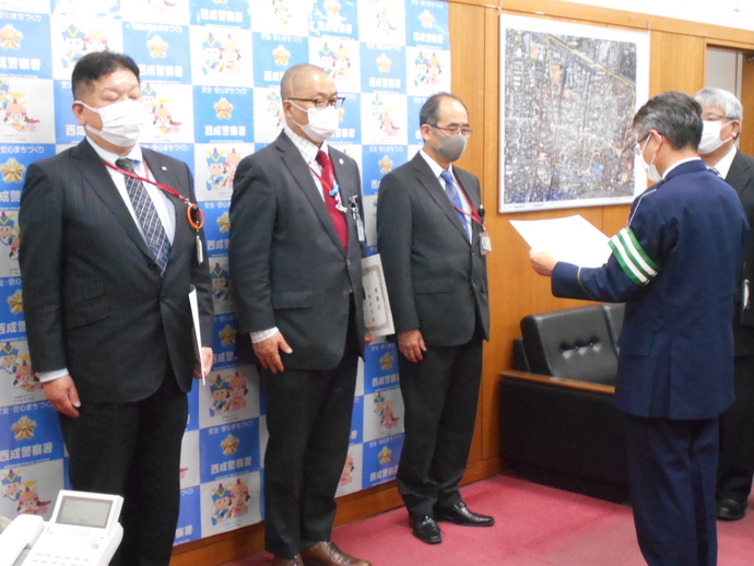感謝状の表彰を受けている西成郵便局の3名の局員の男性の写真