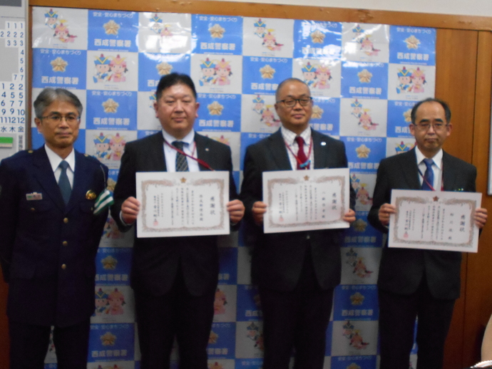 香川署長と表彰状を持っている3名の郵便局員の男性の写真