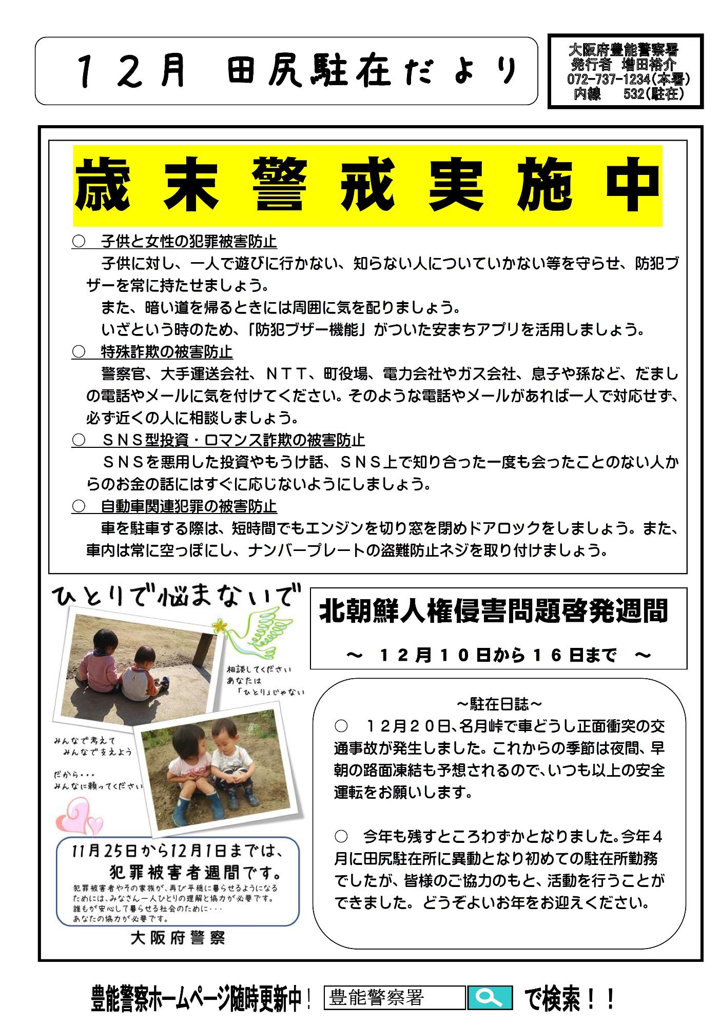 山々を背景に外壁がグレー色の切妻屋根の2階建てで、道路横の外壁に沿って掲示板と周辺地図の案内版が設置され、玄関入口前のスペースにパトカーとバイクが駐車されている田尻駐在所の外観写真