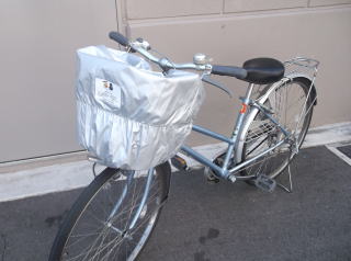 自転車の前カゴに銀色のひったくり防止カバーが取り付けてある写真