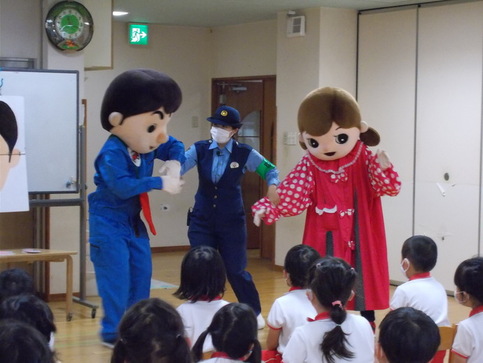 大阪府警察キャラクターゆうかいするぞうくんとれいちゃんの間に女性警察官が入り、2人の手を持って話している写真
