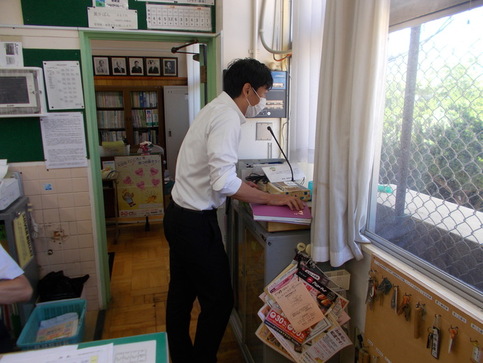 校内放送をしている男性の先生を横から写した写真