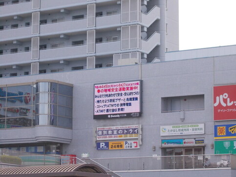 春の地域安全運動に関する広報映像が映し出された河内松原駅の電光掲示板マッキービジョンを写した写真