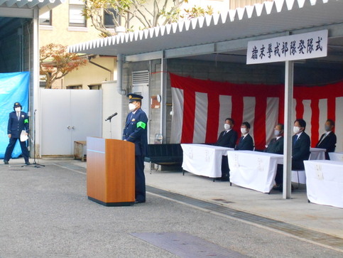 歳末警戒部隊発隊式と書かれた看板が掲げられ、奥の席に来賓が着席し、演壇で署長が挨拶をしている写真