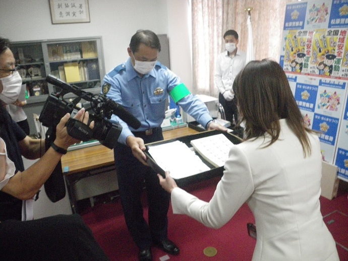 松原警察署長から、第一生命保険株式会社松原営業オフィスのオフィス長にステッカーが渡される写真