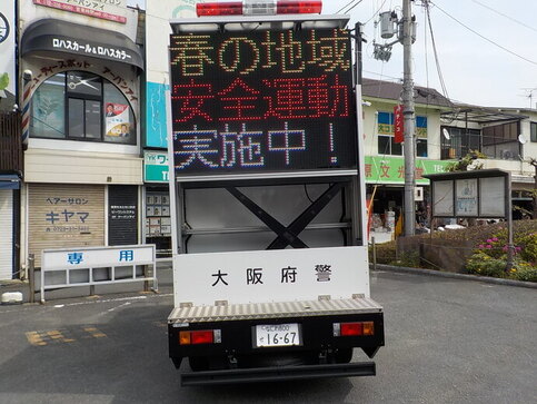 警察車両のサインカーの電光掲示板に春の地域安全運動実施中!と表示されている写真