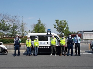 青色パトロールカーの前に3名の警察官と4名の防犯ボランティアの方が立っている写真