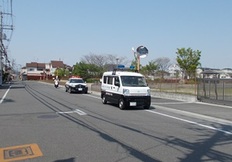 青色パトロール隊を先頭に、パトカー、警ら用の単車に乗った警察官が道路を走っている写真