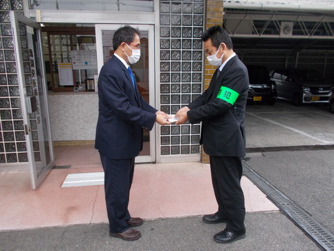 松原交通株式会社の職員に特殊詐欺被害防止の配布用のポケットティッシュを渡している写真