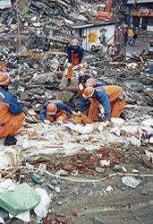 瓦礫が山積した状況で活動をしている国際緊急援助隊の写真