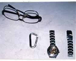眼鏡（黒縁）、丸型腕時計の写真