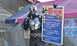 大阪のご当地ヒーロー「地球戦士ゼロス」がパネルを持って5つの約束を呼びかけている様子