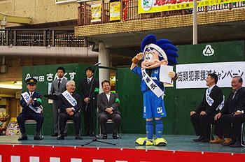 ガンバ大阪マスコットキャラクタ－「ガンバボ－イ」の1日警察署長委嘱式でステージに立つガンバボーイの写真