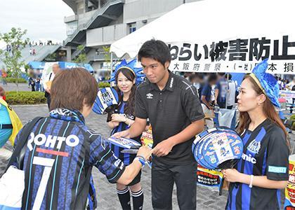 ガンバ大阪の野田裕喜選手が中心となって、来場者にうちわを手渡している様子