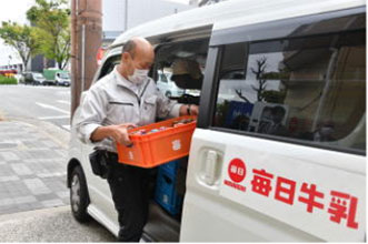 牛乳を宅配用の車両に積み込んでいる様子