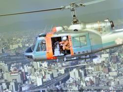 ビル街の上空を飛行するヘリコプターの写真