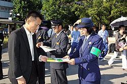 「盗難防止の日」キャンペーンにて該当でチラシを手渡す警察官の写真