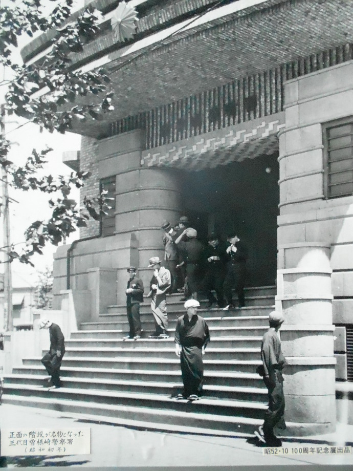 警察章が付いている屋根の下に玄関口があり、大きな12段の階段をメインに撮影した三代目曽根崎警察署庁舎の白黒写真