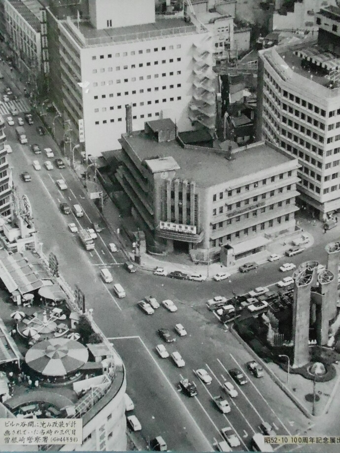 三代目曽根崎警察署庁舎の周囲にビルが建ち並び、車が行き交っている様子を上空から撮影した白黒写真