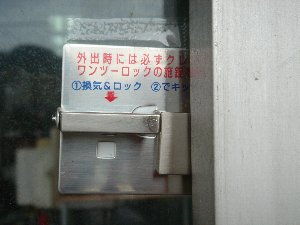 窓に直接貼られており、取り扱い方法が記載されたシルバー色の補助錠の写真