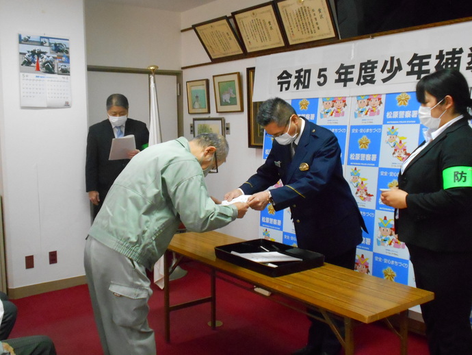 警察署員より委嘱状を手渡されている少年補導員の写真