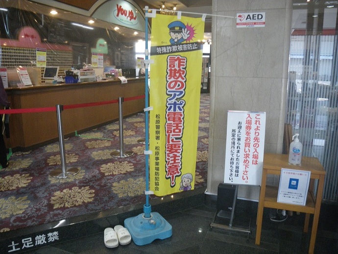 松原天然温泉you、ゆ～フロント前の入口に置かれた詐欺のアポ電話に要注意と書かれたのぼり旗の写真